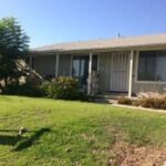 Real estate house with large windows, and a white front door.